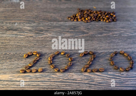 The word 2020 written with coffee beans on wooden table. Concept for new year 2020. Stock Photo