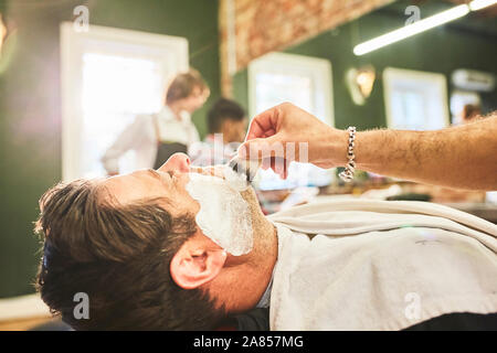 Man getting a shave at barbershop Stock Photo