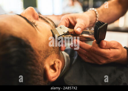 Close up man receiving a shave in barbershop Stock Photo