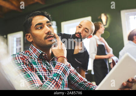 Male customer and barber talking in barbershop Stock Photo