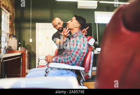 Male barber and customer in barbershop Stock Photo