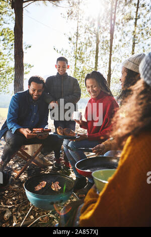 Family cooking around campsite campfire Stock Photo