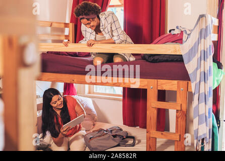 Young female backpackers on bunk bed in youth hostel Stock Photo