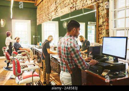 Male barbers working in barbershop Stock Photo