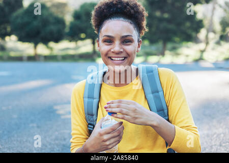 Portrait happy, confident young woman with water bottle Stock Photo