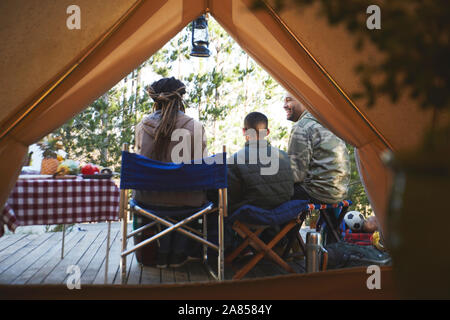 Family relaxing outside camping yurt Stock Photo