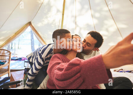 Happy, affectionate family taking selfie in camping yurt Stock Photo