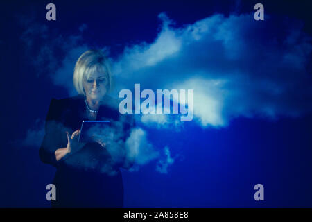 Double exposure businesswoman with digital tablet against blue sky with clouds Stock Photo