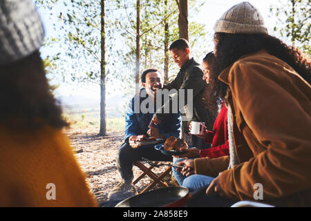 Happy family eating at sunny campsite Stock Photo