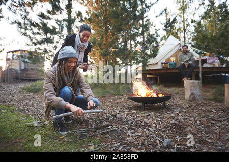 Friends gathering firewood kindling at campsite in woods Stock Photo