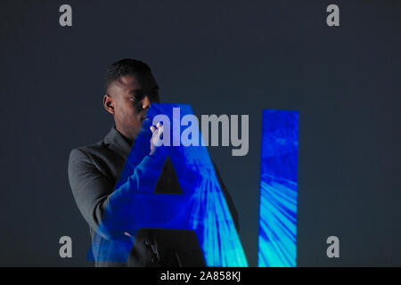 Double exposure thoughtful businessman and AI text Stock Photo