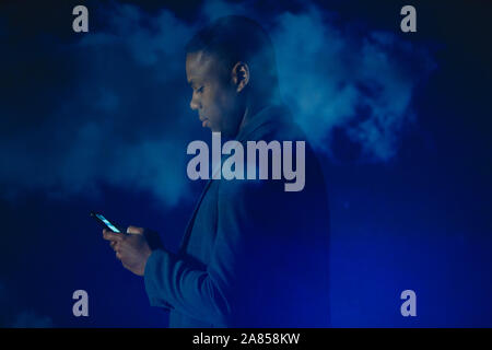 Double exposure businessman with smart phone against blue sky and clouds Stock Photo