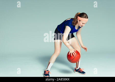 Teenage girl basketball player dribbling ball Stock Photo