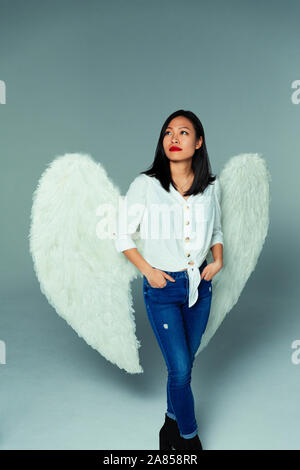 Portrait serene, thoughtful woman wearing angel wings Stock Photo
