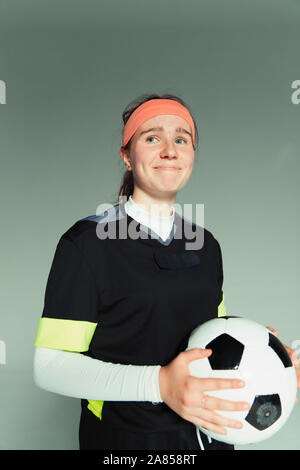 Portrait smiling, confident teenage girl soccer player holding ball Stock Photo