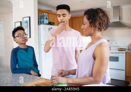 Mother and sons cooking in kitchen Stock Photo