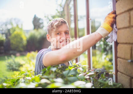 Portrait smiling, confident male worker installing windows on house Stock Photo