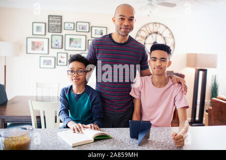 Portrait confident father and sons in kitchen Stock Photo