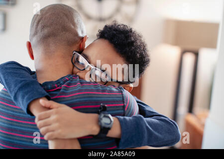 Affectionate son hugging father Stock Photo
