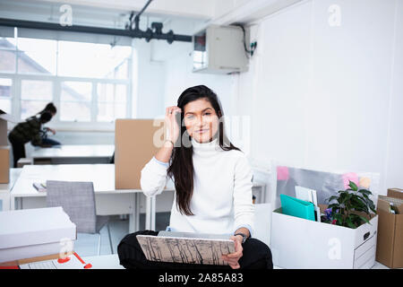 Portrait confident businesswoman using laptop in new office Stock Photo