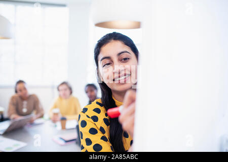 Smiling businesswoman leading conference room meeting Stock Photo