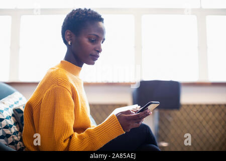 Businesswoman using smart phone in office Stock Photo