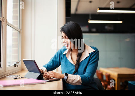 Businesswoman working at digital tablet in office Stock Photo