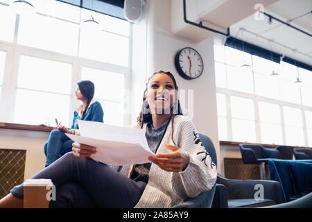 Happy, confident businesswoman with paperwork in office Stock Photo
