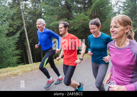 Family jogging on trail in woods Stock Photo
