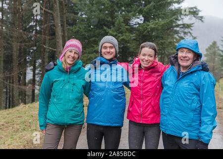 Portrait happy family hiking in rainy woods Stock Photo