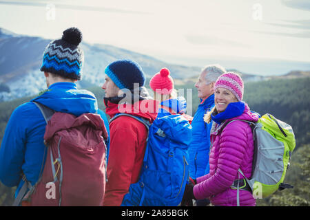 Portrait happy woman hiking on mountain with family Stock Photo