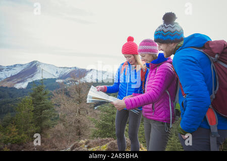 Friends with map hiking with mountains in background Stock Photo