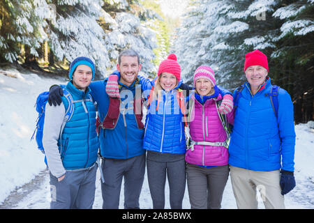 Portrait happy family hiking in snowy woods Stock Photo