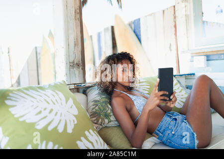 Young woman using digital tablet on beach patio Stock Photo