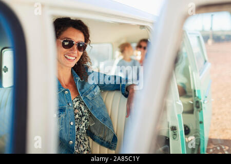 Portrait confident, happy young woman in sunny van Stock Photo