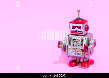 Antique tin toy robot on pink background. Vintage and classic concept free copy space for text. Stock Photo