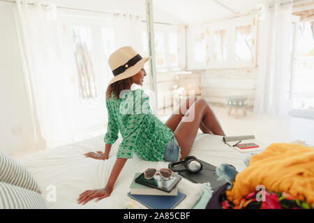 Woman relaxing on beach hut bed Stock Photo