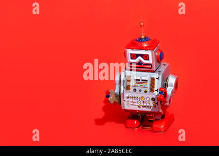 Antique tin toy robot on red background. Vintage and classic concept free copy space for text. Stock Photo