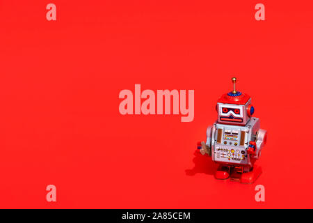 Antique tin toy robot on red background. Vintage and classic concept free copy space for text. Stock Photo