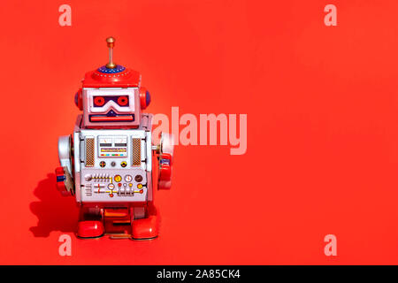 Antique tin toy robot on red background. Vintage and classic concept free copy space for text. Stock Photo