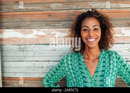 Portrait happy, confident young woman against wood plank wall Stock Photo