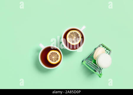 Food and drink concept. Two cups of tea with lemon and marshmallows on a food cart. Mint color. Flat lay, top view, copy space. Stock Photo