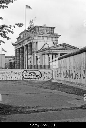Weihnachtswünsche aufgesprüht auf die Mauer in Berlin am Brandenburger Tor, Deutschland 1984. Season's greetings sprayed on the Berlin wall near Brandenburg gate, Germany 1984. Stock Photo