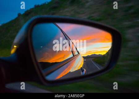 Colorful sunset sky in a rear-view mirror at night Stock Photo