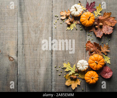 Overhead view of mini pumpkins and fall decor on rustic wooden table. Stock Photo