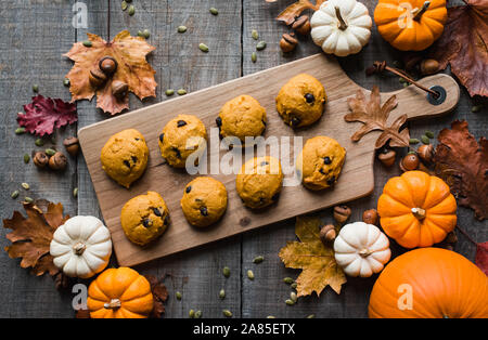 Overhead view of pumpkin chocolate chip cookies on wooden table. Stock Photo