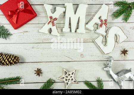 Christmas frame background flat lay on white wood with red gift box xmas text and other natural decoration Stock Photo