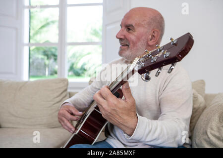 Senior man playing the guitar Stock Photo