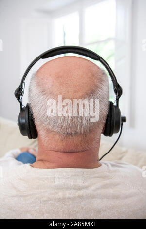 Senior man listening to music on headphones Stock Photo