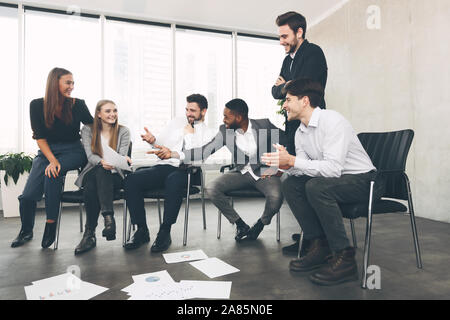 Teamwork and brainstorming. Colleagues discussing blueprints in office Stock Photo